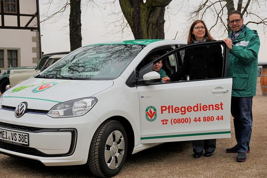 3 People around new e-car of Volkssolidarität Elbtalkreis Meißen
