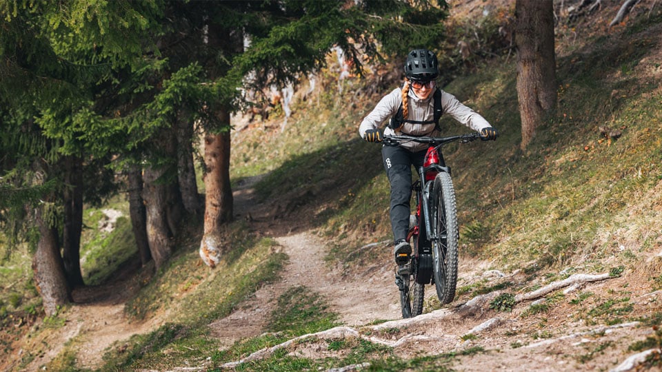 Mountainbikerin mit E-Bike im Wald